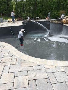 Men Filling Swimming Pool with Water